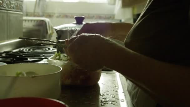 Cámara lenta de la mujer mayor cocinando en su cocina — Vídeos de Stock