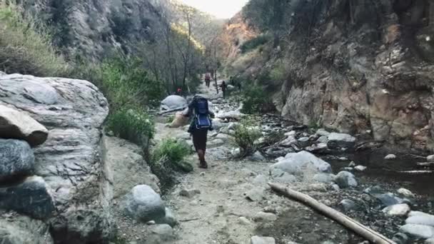 Le persone che camminano attraverso le rocce in montagna — Video Stock