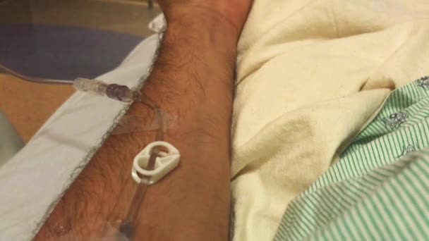 Close-up dos braços do homem abrindo e fechando a mão enquanto usava um IV no hospital — Vídeo de Stock