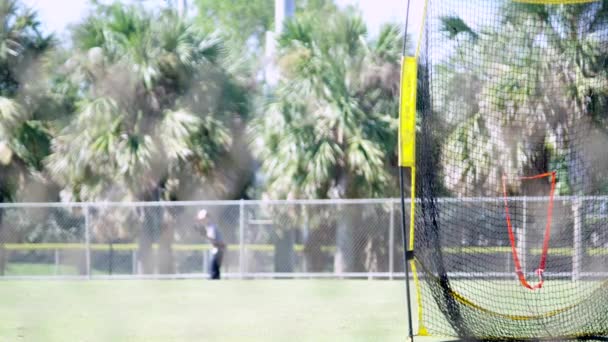 Trainingsnetz auf einem Baseballfeld, im Hintergrund spielt ein Kind — Stockvideo
