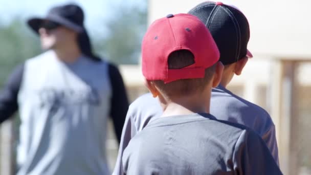 Медленное движение детей, стоящих вокруг во время бейсбольной тренировки — стоковое видео