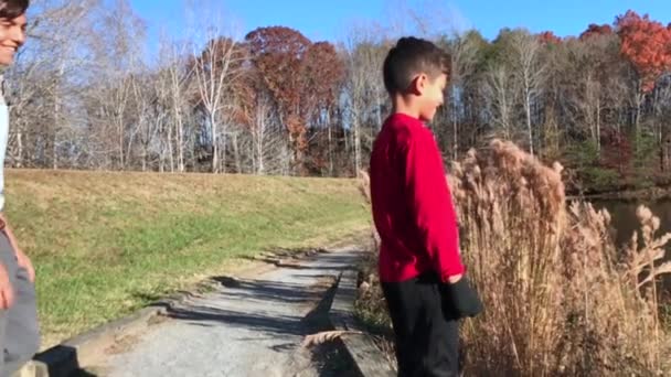 两兄弟在秋季的一个伟大的一天在湖边玩耍的慢动作 — 图库视频影像