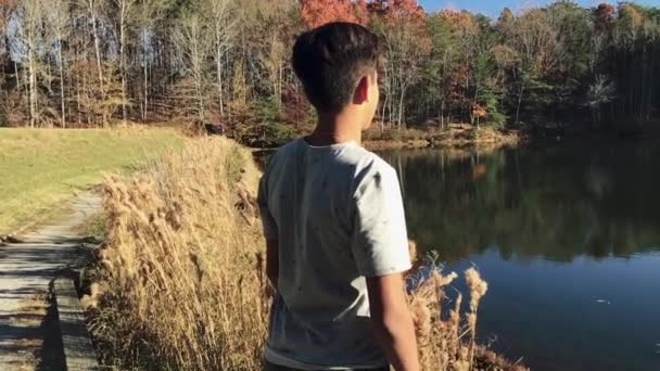 Großartige Zeitlupenaufnahme Von Hinten Eines Teenagers Der Auf Einen See — Stockvideo