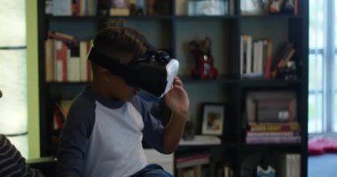 Yavaş hareket bir baba oğlunu kucağına evde otururken bir Vr kulaklık oyun izlerken