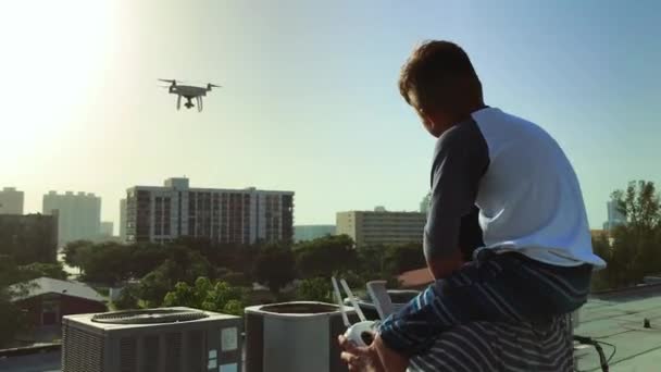 Tiro Pai Criança Voando Drone Cima Edifício Enquanto Criança Senta — Vídeo de Stock