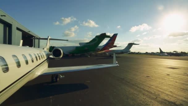 日没の時間帯に専用の空港に駐機している飛行機のパン ショット — ストック動画