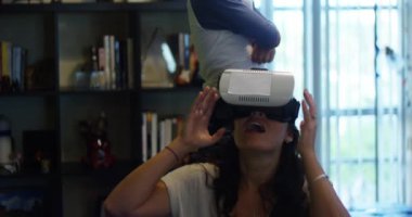 Ağır çekim bir kadının oğlu onun yapma yüzler duran bir sanal gerçeklik kulaklık ile oynarken