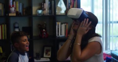 Ağır çekim shot Vr ile oynarken annesi izlerken bir çocuğun evde koruyucu gözlük