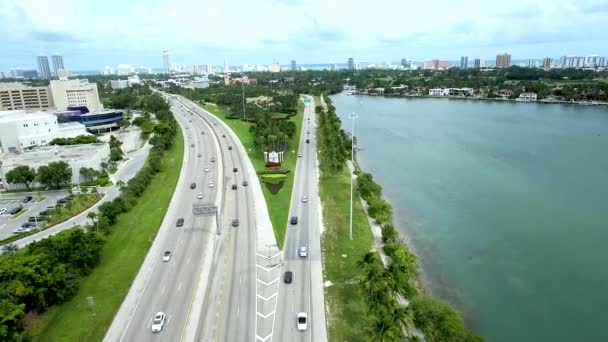 水の隣の道路上のマイアミビーチ フロリダ州を出入りする車の昼間の空中ショット — ストック動画