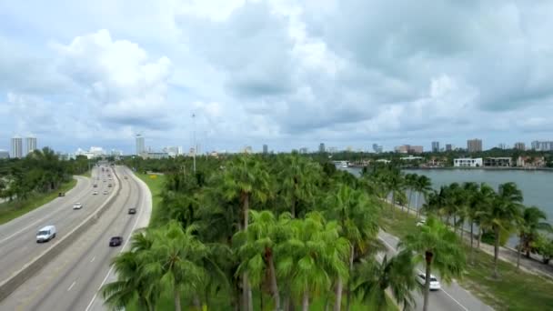 マイアミビーチへようこそと言う看板に降りてくるマイアミビーチの入り口の昼間の空中ショット — ストック動画
