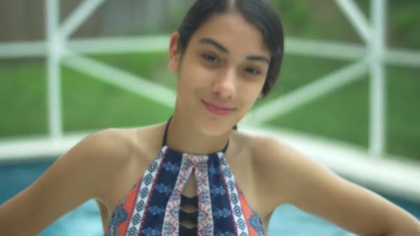 Giovane ragazza con bretelle sorridente alla macchina fotografica in piscina — Video Stock