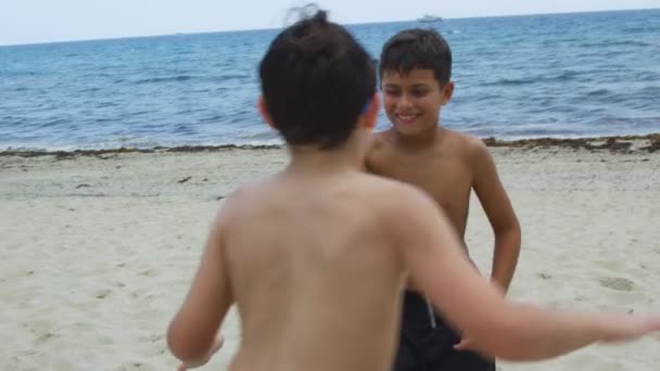 Mouvement lent de deux enfants jouant à la plage — Video