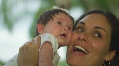 Bebeği tutan ve gülümsüyor kadının yavaş hareket