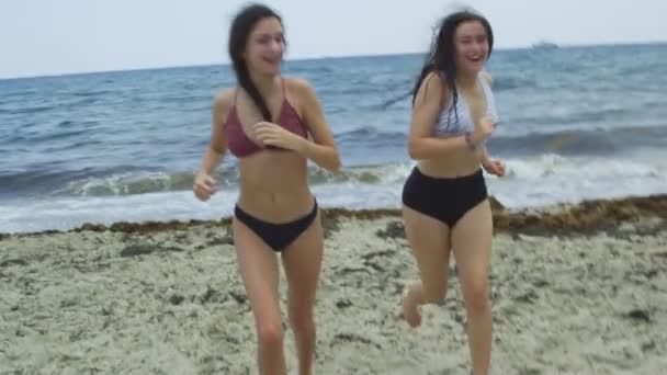 Mouvement lent des filles à la plage courant vers la caméra de l'océan — Video