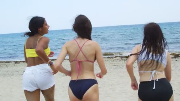 Slow motion tonåringar på stranden kör mot havet — Stockvideo