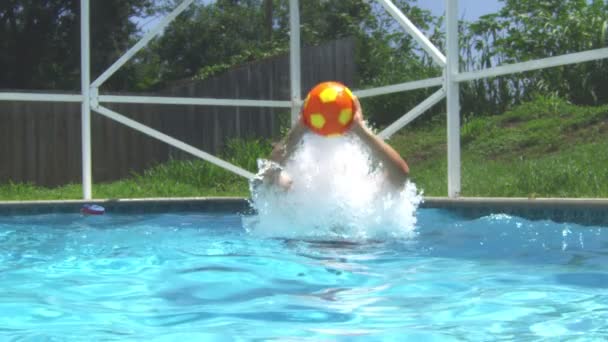 Медленное движение человека, выпрыгивающего из воды в бассейн и бросающего мяч — стоковое видео