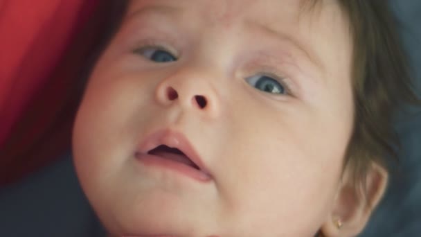 Close-up van mooie baby meisje kijken naar camera — Stockvideo