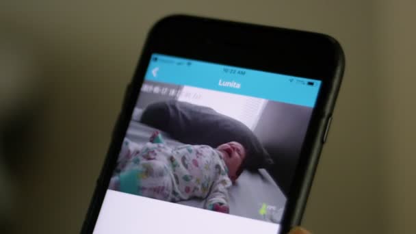 Gros plan d'un téléphone cellulaire montrant l'image du bébé à partir du moniteur de bébé — Video