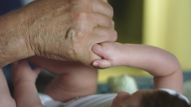 Όμορφη αργή κίνηση των χεριών της μπέιμπι σίτερ κρατώντας τους παππούδες δάχτυλο — Αρχείο Βίντεο