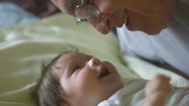 Schöne Zeitlupe von Baby und Großvater, die einander anschauen — Stockvideo