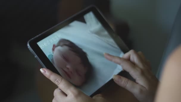 Mouvement lent de la femme regardant son bébé sur tablette et l'embrassant 