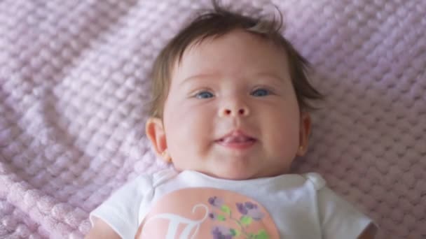 Movimento lento do bebê bonito com olhos azuis olhando para a câmera — Vídeo de Stock