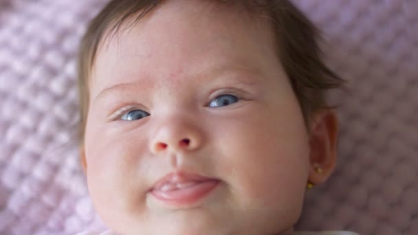 Крупный план малышки с красивыми глазами, смотрящей в камеру — стоковое видео
