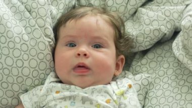 Yatakta yatan güzel gözleri ile bebeğin yavaş hareket