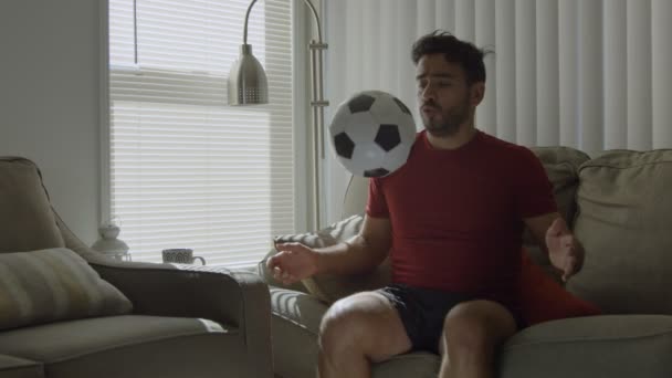 Lento movimiento de un hombre jugando con pelota de fútbol en casa — Vídeos de Stock