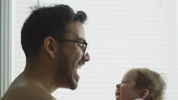 Schöne Zeitlupe von Papa, der sein Baby hochhebt und lächelt — Stockvideo