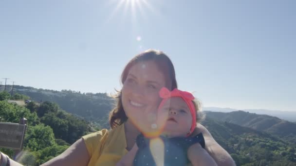 Madre tomando selfie con la hija del bebé delante de la hermosa vista de la montaña — Vídeo de stock