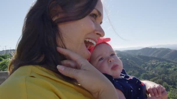 Slow Motion av Mother Holding baby dotter framför vacker utsikt — Stockvideo