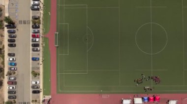 Dağlarla çevrili bir futbol sahasının üzerinden havadan çekim.