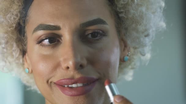 Счастливая трансгендерная женщина красит губы — стоковое видео