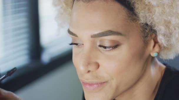 Transgender woman smiling as she puts mascara on — Stock Video