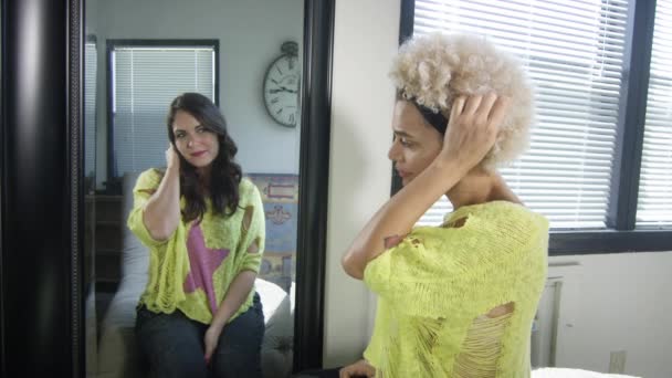 Трансгендерная женщина видит другую женщину через зеркало, подражает ей — стоковое видео