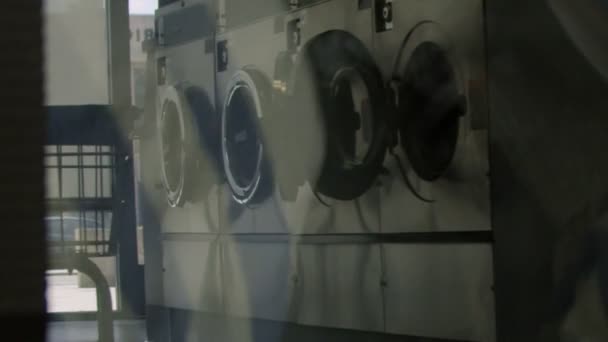 Reflection of washing machines through a spinning dryer — ストック動画