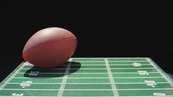 Macro shot of football ball on top of toy football field — Stock Video