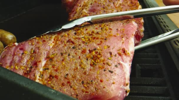 Slow motion macro shot of seasoned ribs being put on bbq grill — Stock Video