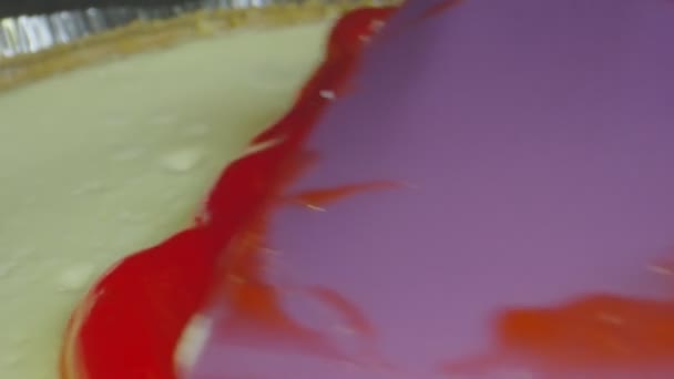 Macro shot van aardbeienglazuur wordt verspreid op de top van een taart — Stockvideo
