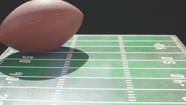 Close-up of football ball on top of a toy football field — Stock Video