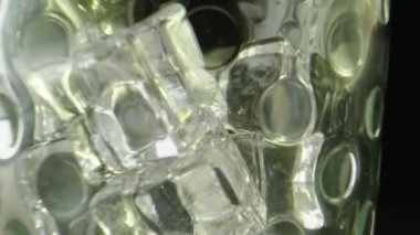 Buzlu, siyah arka planlı, berrak bir bardağın makro görüntüsü..