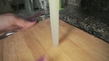 Kesme tahtasının kadın eliyle yıkanmasına yakın plan.