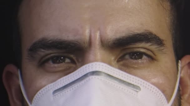 Barna szemű és maszkot viselő férfi arcáról készült közeli kép — Stock videók
