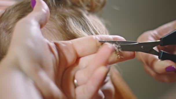 Primer plano de las madres manos tratando de cortar el pelo hijas en casa — Vídeos de Stock