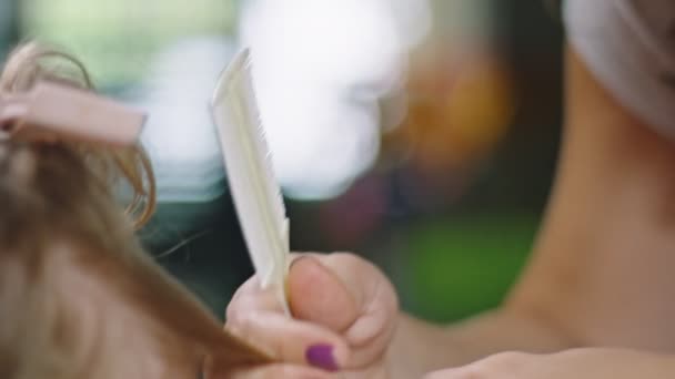 Close-up in slow motion of mother cutting daughters hair at home — Stock Video