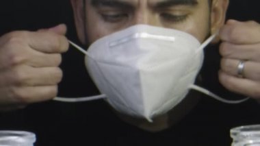 Adam yüz maskesi takmadan önce mumların etrafında dua ediyor.. 