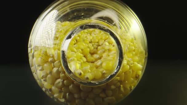 Macro shot moving to the inside of a jar filled with popcorn seeds — Stock Video