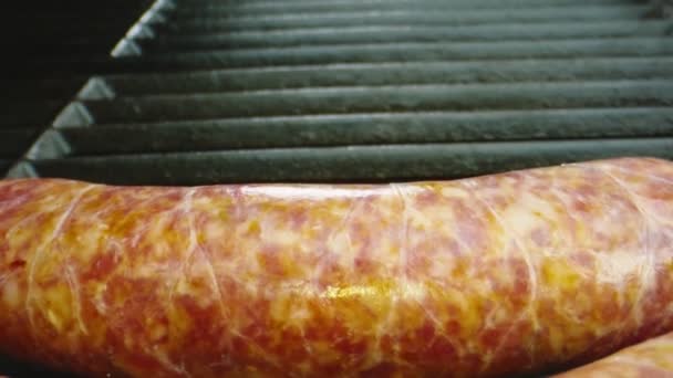 Macro shot of sausages being put on bbq grill — Stock Video