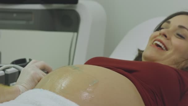 Femeia gravidă zâmbind în timp ce primește o ecografie — Videoclip de stoc